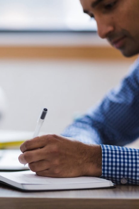 A man taking notes in a notebook.